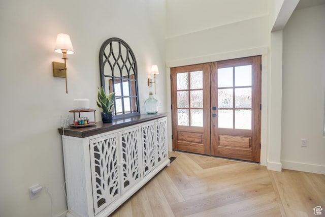 entryway featuring baseboards and french doors