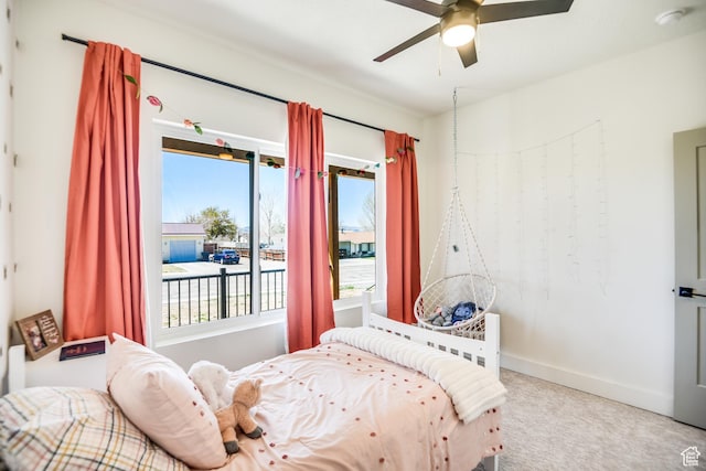 bedroom featuring carpet floors, multiple windows, baseboards, and a ceiling fan