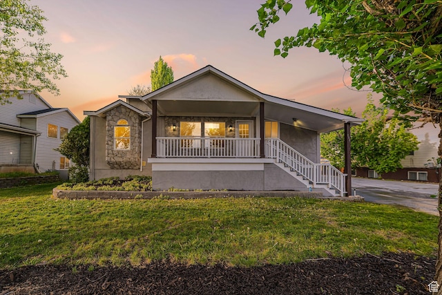 single story home featuring stone siding, stucco siding, a porch, stairway, and a front yard