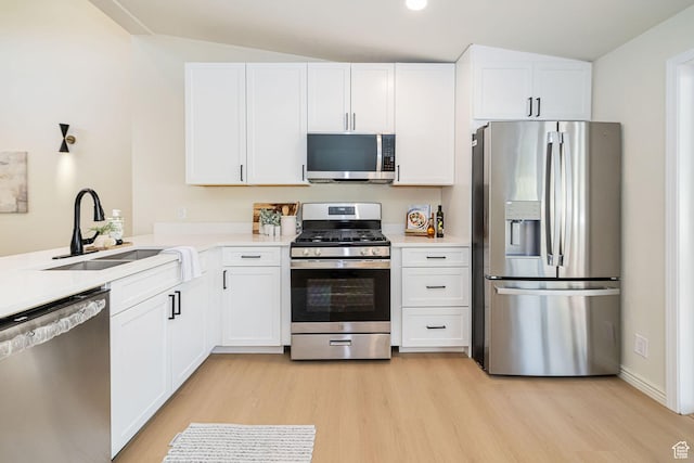 916 W 1150 S, Provo, UT 84601 - kitchen with white cabinets, a sink, light wood-style flooring, stainless steel appliances, and vaulted ceiling
