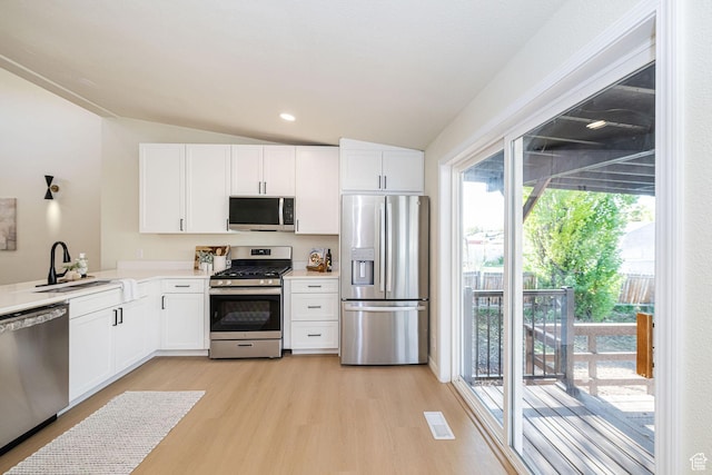 916 W 1150 S, Provo, UT 84601 - kitchen with light wood-style floors, white cabinetry, a sink, vaulted ceiling, and stainless steel appliances