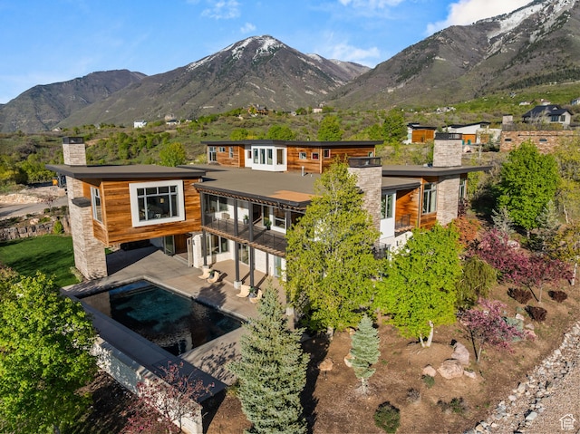 772 S Summit Creek Dr, Woodland Hills, UT 84653 - rear view of property with a chimney, a balcony, a mountain view, and an outdoor pool
