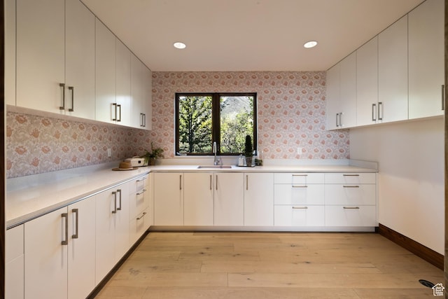 772 S Summit Creek Dr, Woodland Hills, UT 84653 - kitchen featuring a sink, light wood finished floors, light countertops, decorative backsplash, and white cabinetry