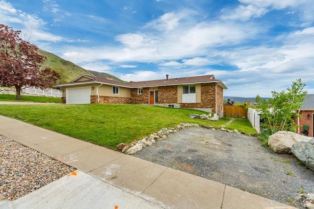 584 E Aspen Way, Centerville, UT 84014 - ranch-style house with stone siding, an attached garage, fence, and a front yard