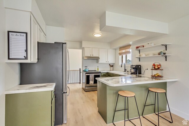 584 E Aspen Way, Centerville, UT 84014 - kitchen with light countertops, stainless steel appliances, a peninsula, a kitchen bar, and under cabinet range hood