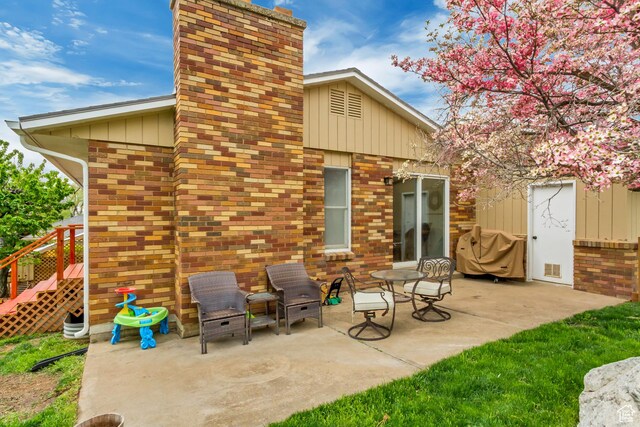 584 E Aspen Way, Centerville, UT 84014 - back of house featuring brick siding, a patio area, and a chimney