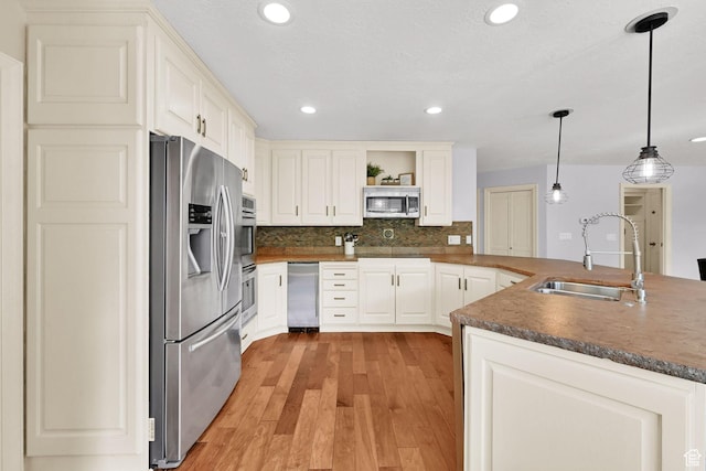 5078 S Iroquois Way E, Ogden, UT 84403 - kitchen with open shelves, dark countertops, a sink, light wood-style flooring, and stainless steel appliances