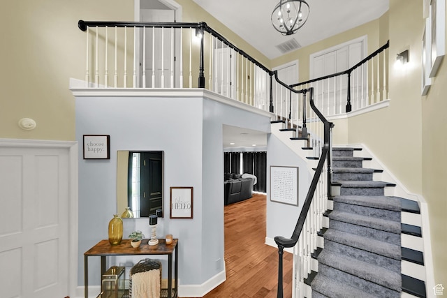 5078 S Iroquois Way E, Ogden, UT 84403 - stairs featuring visible vents, a towering ceiling, wood finished floors, baseboards, and a chandelier