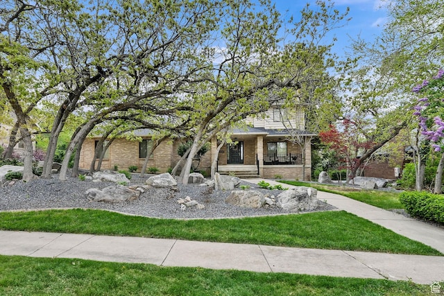 5078 S Iroquois Way E, Ogden, UT 84403 - obstructed view of property featuring covered porch, brick siding, and a front lawn