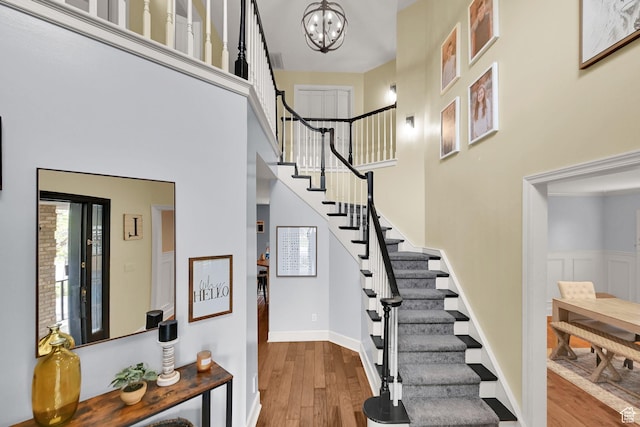 5078 S Iroquois Way E, Ogden, UT 84403 - staircase with an inviting chandelier, baseboards, a towering ceiling, and wood finished floors