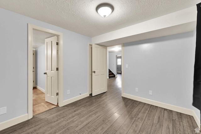5078 S Iroquois Way E, Ogden, UT 84403 - finished basement featuring a textured ceiling, baseboards, stairs, and wood finished floors