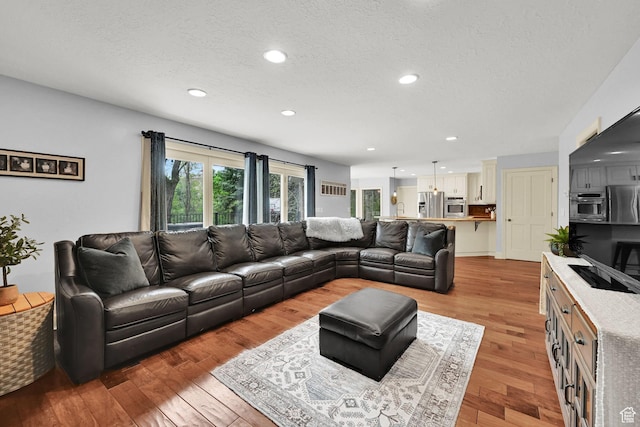 5078 S Iroquois Way E, Ogden, UT 84403 - living area featuring recessed lighting, a textured ceiling, and light wood finished floors