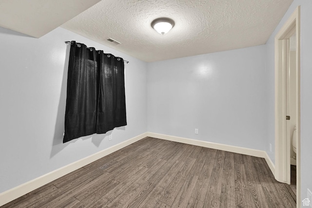 5078 S Iroquois Way E, Ogden, UT 84403 - unfurnished room featuring wood finished floors, baseboards, a textured ceiling, and visible vents
