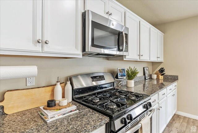 204 E 460 N, Vineyard, UT 84059 - kitchen with baseboards, white cabinets, dark stone countertops, stainless steel appliances, and light wood-style flooring