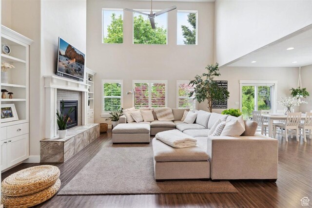 1485 E Peachtree Ln, Fruit Heights, UT 84037 - living area with dark wood-type flooring, a towering ceiling, built in shelves, and a fireplace