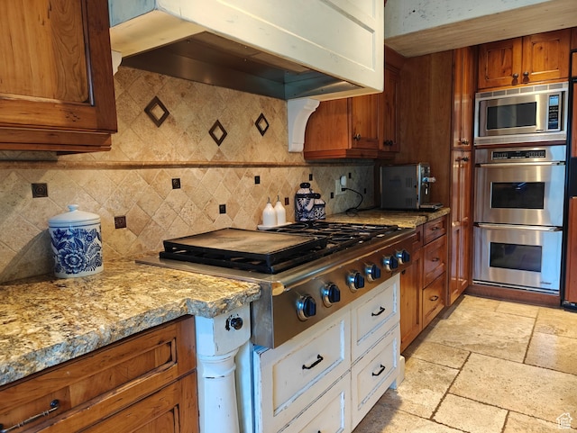 418 E Bridlewalk Ln, Murray, UT 84107 - kitchen featuring light stone countertops, appliances with stainless steel finishes, brown cabinetry, custom range hood, and tasteful backsplash