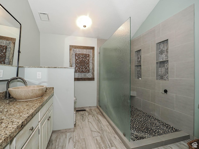 418 E Bridlewalk Ln, Murray, UT 84107 - full bathroom with visible vents, tiled shower, vaulted ceiling, and vanity