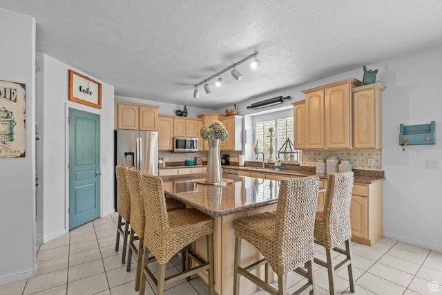 6272 S Lake Fork Cir, Taylorsville, UT 84129 - kitchen featuring light brown cabinetry, appliances with stainless steel finishes, decorative backsplash, and light tile patterned flooring