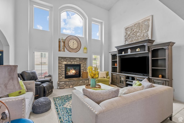 6272 S Lake Fork Cir, Taylorsville, UT 84129 - living room featuring a towering ceiling, light carpet, a fireplace, baseboards, and arched walkways
