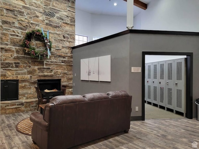 1940 Prospector Ave Unit 207, Park City, UT 84060 - living room featuring wood finished floors, beam ceiling, a stone fireplace, baseboards, and a high ceiling