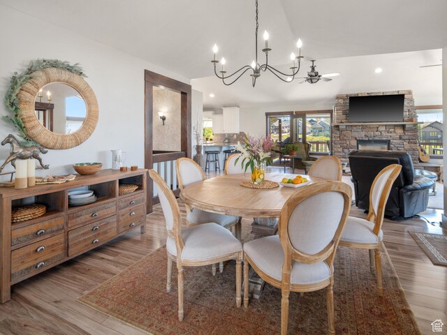 3540 N Elkview Dr, Eden, UT 84310 - dining area featuring an inviting chandelier, light wood-style flooring, vaulted ceiling, and a fireplace
