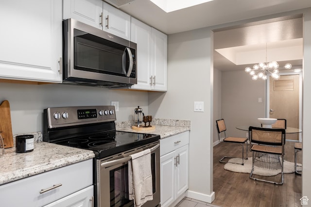 636 E 3990 S Unit D, Millcreek, UT 84107 - kitchen featuring a notable chandelier, light wood finished floors, stainless steel appliances, baseboards, and white cabinetry