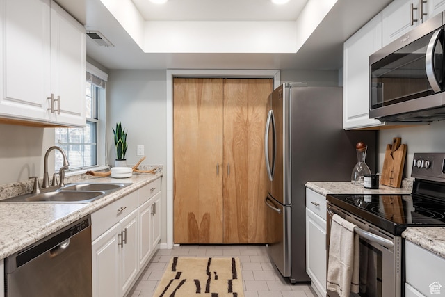 636 E 3990 S Unit D, Millcreek, UT 84107 - kitchen with a tray ceiling, a sink, white cabinets, stainless steel appliances, and light tile patterned flooring
