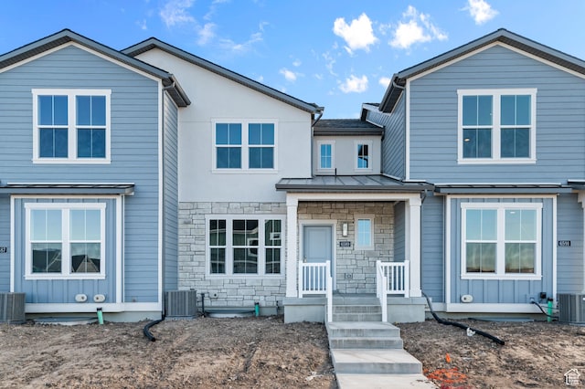 6589 W Bannon St, West Jordan, UT 84081 - view of front facade with central air condition unit, a standing seam roof, metal roof, and stone siding