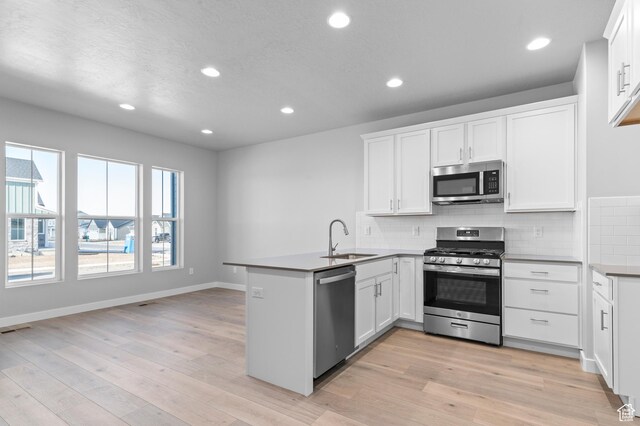 6589 W Bannon St, West Jordan, UT 84081 - kitchen featuring decorative backsplash, appliances with stainless steel finishes, a sink, a peninsula, and recessed lighting