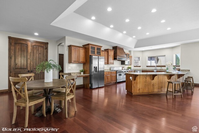 1328 N Parkside Dr, Cedar City, UT 84721 - kitchen with a breakfast bar area, brown cabinetry, stainless steel appliances, recessed lighting, and dark wood-type flooring
