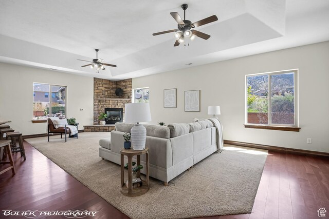 1328 N Parkside Dr, Cedar City, UT 84721 - living room featuring a fireplace, dark wood finished floors, a ceiling fan, baseboards, and a tray ceiling