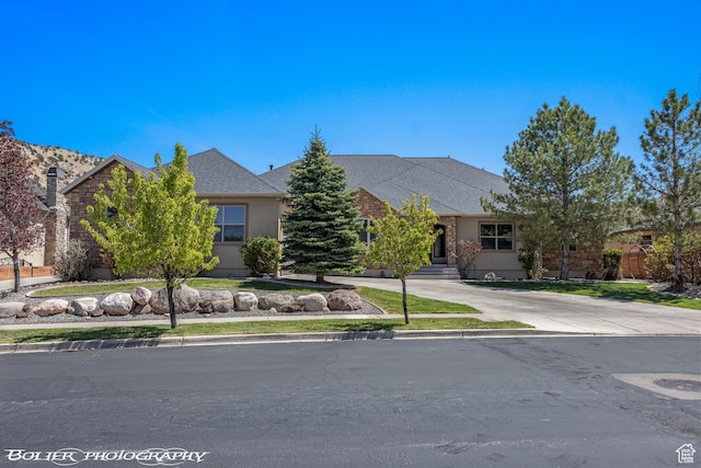 1328 N Parkside Dr, Cedar City, UT 84721 - view of property hidden behind natural elements with driveway, a shingled roof, and stucco siding