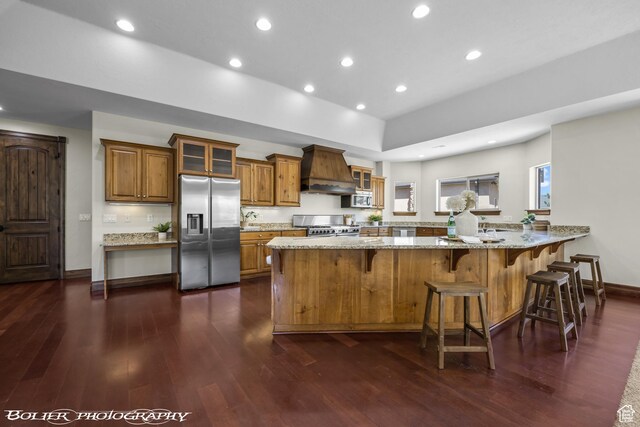 1328 N Parkside Dr, Cedar City, UT 84721 - kitchen featuring brown cabinetry, light stone countertops, custom exhaust hood, a peninsula, and stainless steel appliances