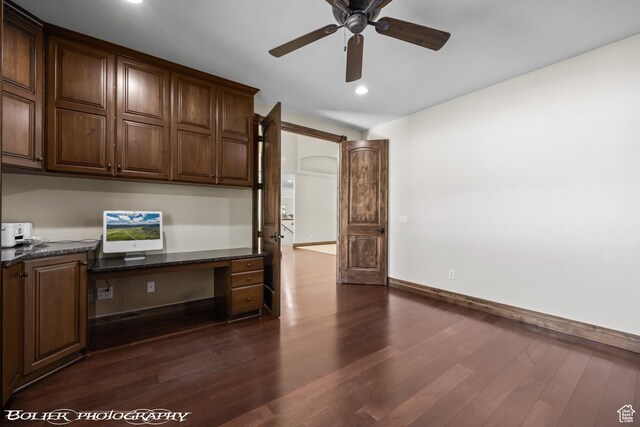 1328 N Parkside Dr, Cedar City, UT 84721 - unfurnished office with a ceiling fan, baseboards, built in desk, and dark wood-type flooring
