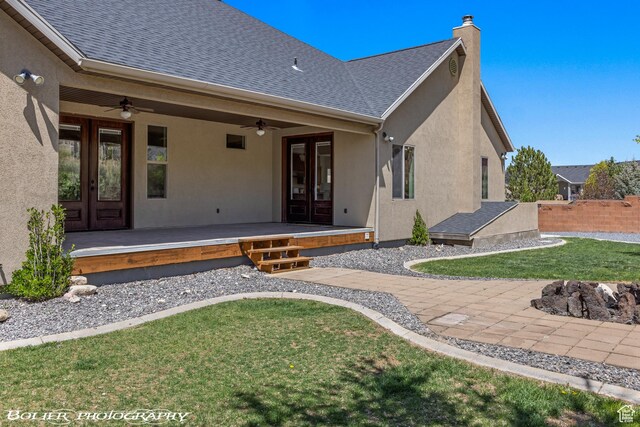 1328 N Parkside Dr, Cedar City, UT 84721 - rear view of house featuring stucco siding, french doors, a chimney, a ceiling fan, and a lawn