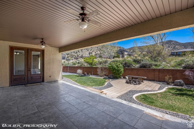 1328 N Parkside Dr, Cedar City, UT 84721 - view of patio with french doors, a mountain view, a ceiling fan, and a fenced backyard