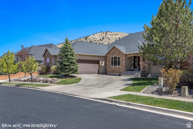 1328 N Parkside Dr, Cedar City, UT 84721 - ranch-style house featuring a mountain view, concrete driveway, an attached garage, stone siding, and stucco siding