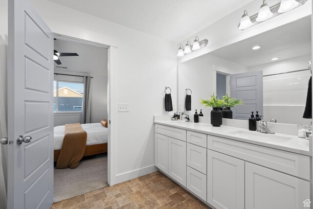 13077 S Keegan Dr, Herriman, UT 84096 - ensuite bathroom featuring baseboards, a sink, stone finish floor, and double vanity