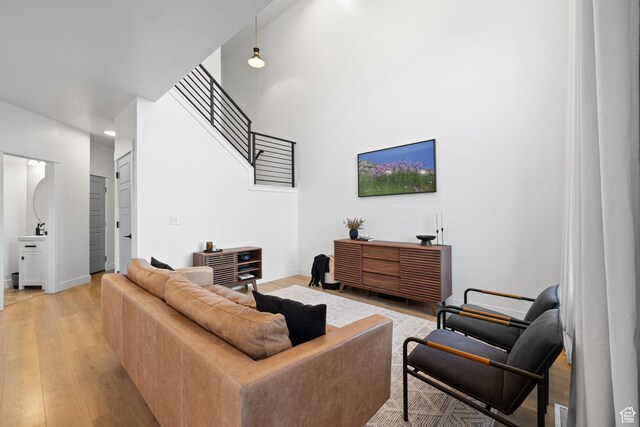 13077 S Keegan Dr, Herriman, UT 84096 - living room with light wood-style floors, baseboards, a high ceiling, and stairway