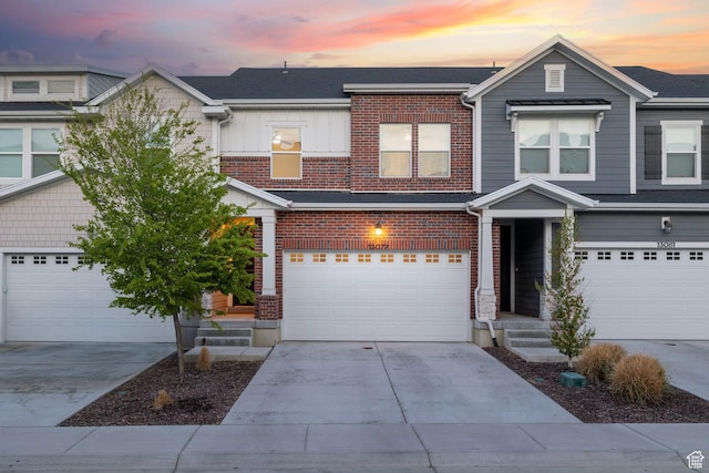 13077 S Keegan Dr, Herriman, UT 84096 - view of front of home featuring brick siding, a garage, board and batten siding, and concrete driveway