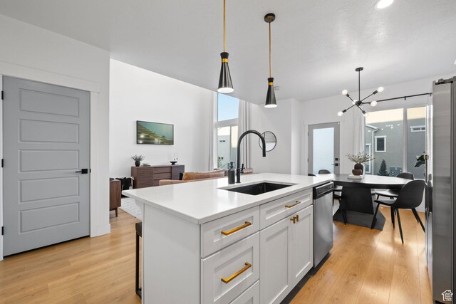 13077 S Keegan Dr, Herriman, UT 84096 - kitchen with light countertops, white cabinets, a sink, light wood-style flooring, and stainless steel appliances
