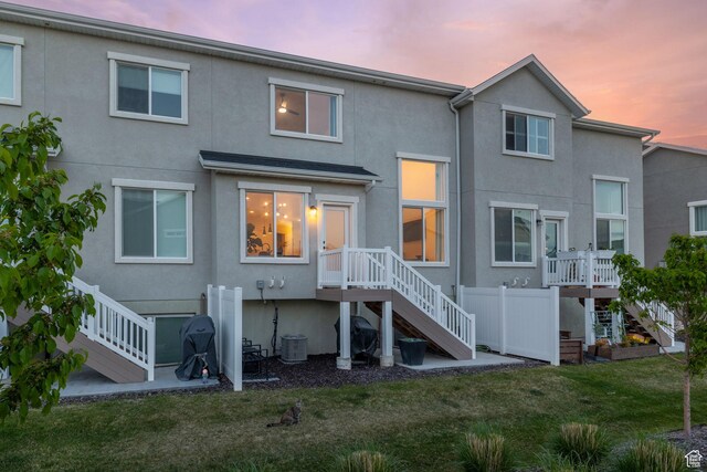 13077 S Keegan Dr, Herriman, UT 84096 - back of house at dusk with stairs, stucco siding, and a yard