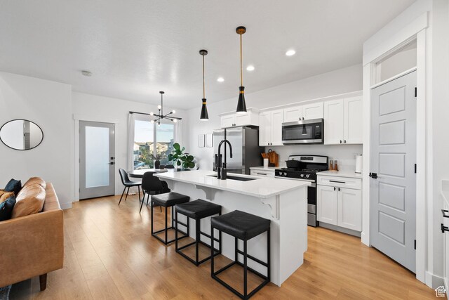 13077 S Keegan Dr, Herriman, UT 84096 - kitchen featuring a kitchen island with sink, a kitchen breakfast bar, recessed lighting, a chandelier, and appliances with stainless steel finishes