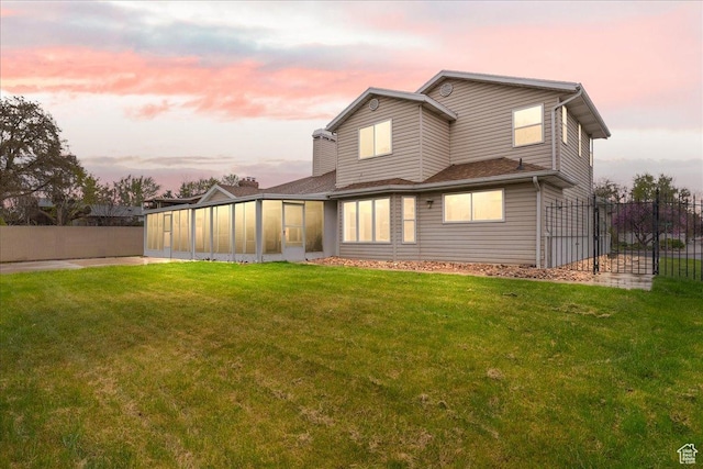 2748 W 220 N, Provo, UT 84601 - back of property at dusk with a lawn, fence, and a sunroom