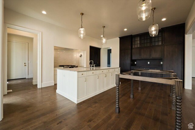 473 W 350 S Unit 31, Mapleton, UT 84664 - kitchen with dark wood-style flooring, a kitchen island with sink, dark brown cabinets, and glass insert cabinets