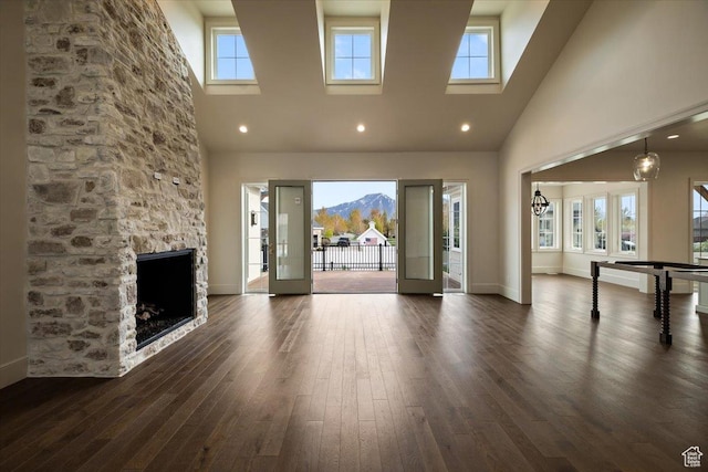 473 W 350 S Unit 31, Mapleton, UT 84664 - unfurnished living room featuring dark wood-style flooring, baseboards, a stone fireplace, and a towering ceiling