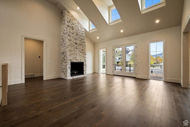 473 W 350 S Unit 31, Mapleton, UT 84664 - unfurnished living room with baseboards, a stone fireplace, high vaulted ceiling, dark wood-type flooring, and a skylight