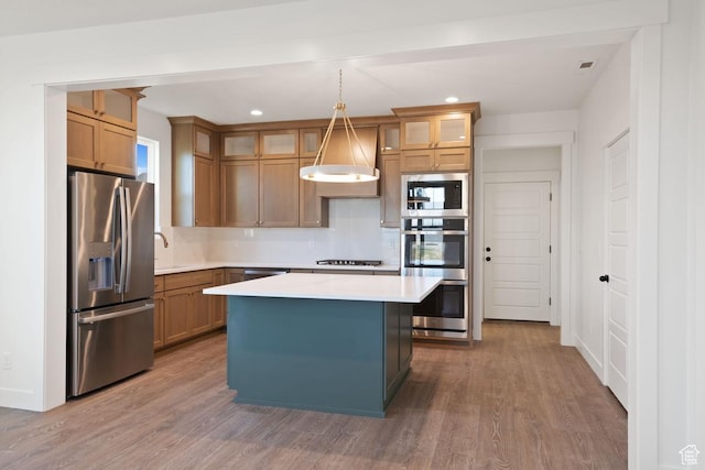 11439 S Watercourse Rd Unit 182, South Jordan, UT 84009 - kitchen featuring stainless steel appliances, light countertops, wood finished floors, a center island, and recessed lighting