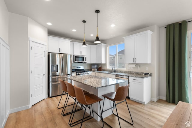 838 N Marble Rd, Tooele, UT 84074 - kitchen with a center island, a sink, white cabinets, and stainless steel appliances