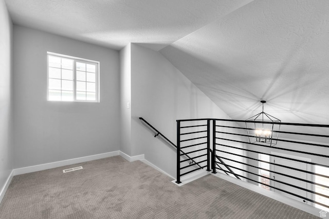 6628 W Spring Snow Ln, Herriman, UT 84096 - staircase with a chandelier, a textured ceiling, carpet flooring, lofted ceiling, and baseboards